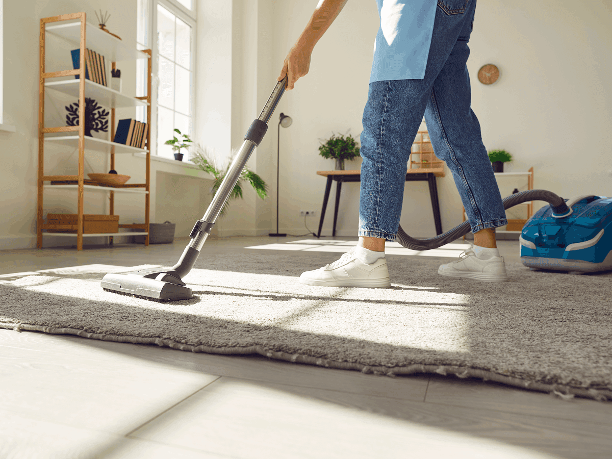 Professionnel en tenue effectuant le nettoyage d’un intérieur lumineux.